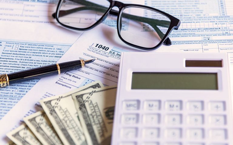 Calculator and money on top of tax forms