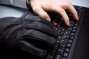 Man with black glove stealing data from tax professionals